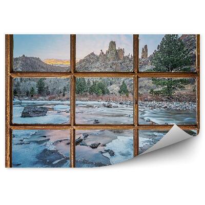 Fototapet vintage Fereastră veche cu vedere la munți și la pârâul înghețat