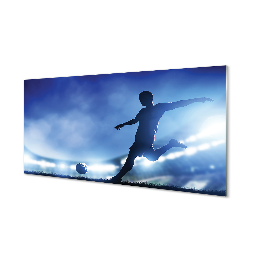 Tablou pe sticlă Jucător De Fotbal Lovind Mingea Cu Fundal Albastru
